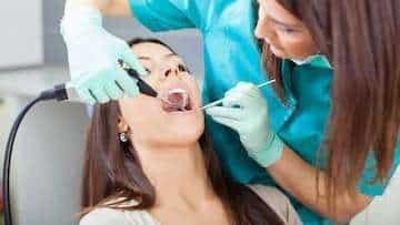 woman receiving dental exam | tooth extractions seattle