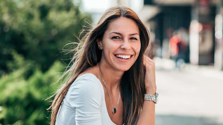 woman with long brown hair smiling | dentist near me seattle wa
